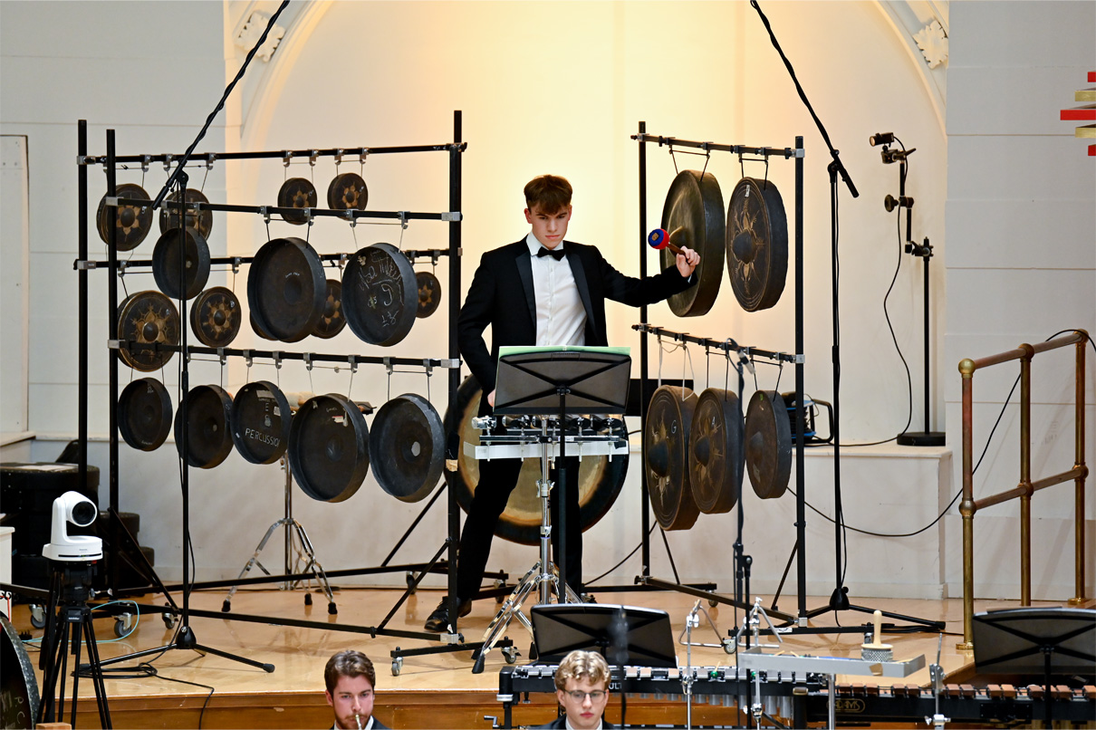  A male student playing percussion in an orchestra performance.